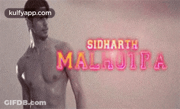 A Man Without A Shirt Is Standing In Front Of A Sign That Says Siddharth Malhotra GIF