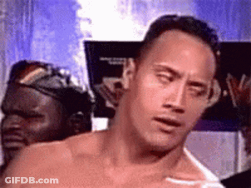 A Man Without A Shirt Is Standing In Front Of A Sign That Says `` The Rock '' . GIF