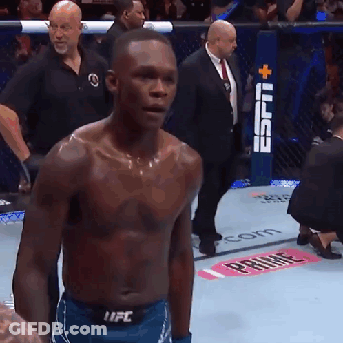 A Man Without A Shirt Is Standing In Front Of A Ufc Advertisement GIF