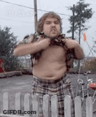 A Man Without A Shirt Is Standing In Front Of A White Fence . GIF
