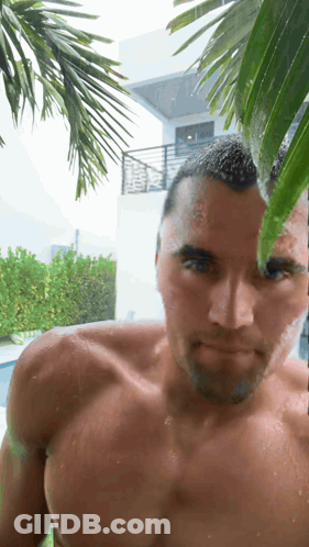 A Man Without A Shirt Is Standing In The Rain GIF