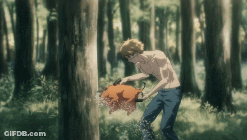 A Man Without A Shirt Is Standing In The Woods Holding A Pig GIF