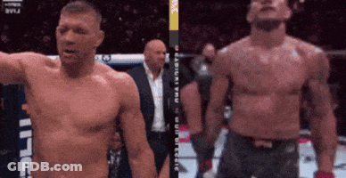 A Man Without A Shirt Is Standing Next To Another Shirtless Man In A Boxing Ring GIF