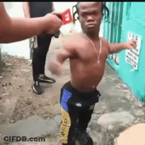 A Man Without A Shirt Is Standing On A Sidewalk In Front Of A Sign That Says ' A ' On It GIF