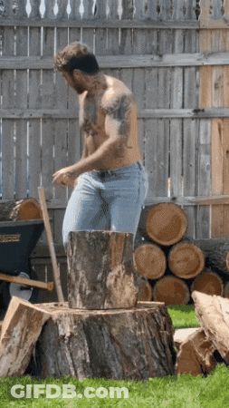 A Man Without A Shirt Is Standing On A Tree Stump With An Axe GIF