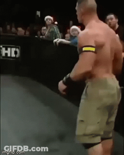 A Man Without A Shirt Is Standing On A Wrestling Ring . GIF