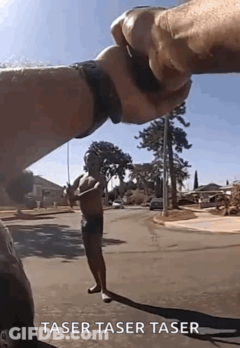 A Man Without A Shirt Is Standing On The Side Of The Road Being Held By Another Man 'S Hand . GIF