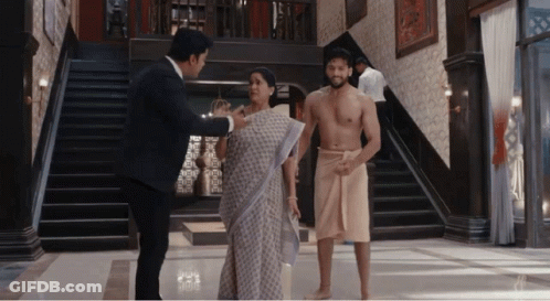 A Man Without A Shirt Is Talking To A Woman And A Man In A Towel GIF