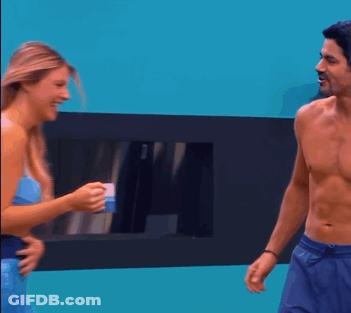 A Man Without A Shirt Is Talking To A Woman In A Mermaid Costume GIF