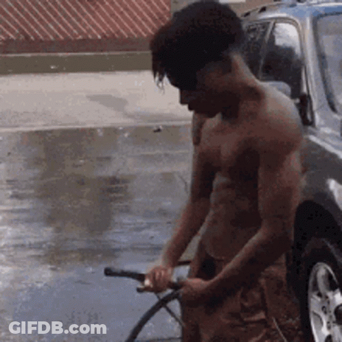 A Man Without A Shirt Is Washing A Car With A Hose GIF