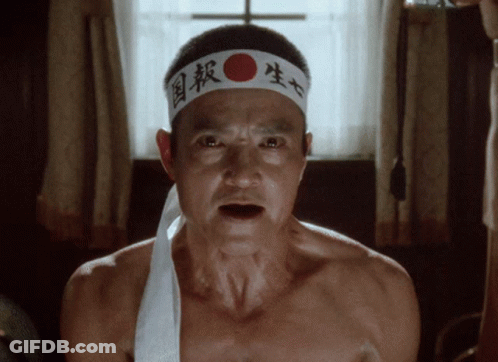 A Man Without A Shirt Is Wearing A Headband With Chinese Characters On It GIF