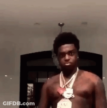 A Man Without A Shirt Is Wearing A Necklace And Earrings . GIF