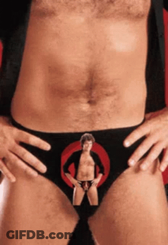 A Man Without A Shirt Is Wearing Black Underwear With A Picture Of A Man In A Circle On It GIF
