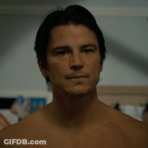 A Man Without A Shirt Looks At The Camera With A Serious Look On His Face GIF