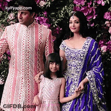 A Man , Woman , And Child Are Posing For A Picture . GIF