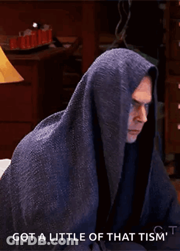 A Man Wrapped In A Blanket With The Words Got A Little Of That Tism 'T Written Below Him GIF