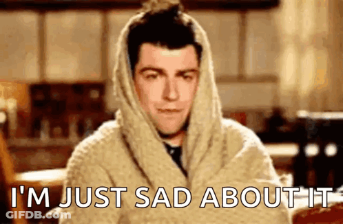 A Man Wrapped In A Blanket With The Words `` I 'M Just Sad About It '' On His Face . GIF