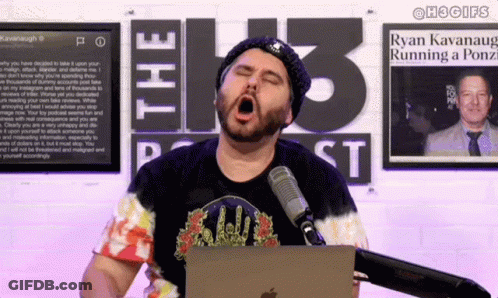 A Man Yawning In Front Of A Microphone In Front Of A Sign That Says The 13 Podcast GIF