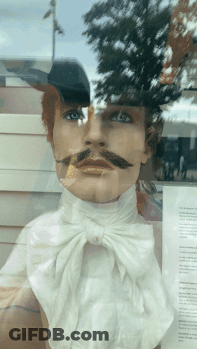 A Mannequin With A Mustache Is Behind A Window GIF