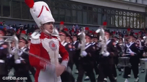 A Marching Band Is Performing In Front Of A Live Abc Sign GIF