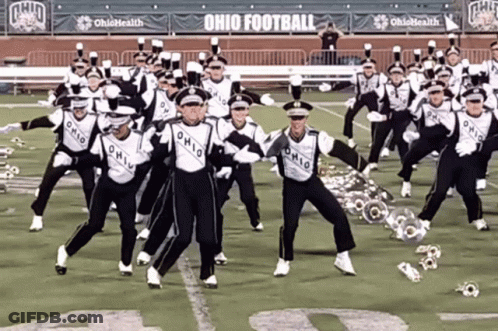 A Marching Band Is Performing On A Field With Ohio Football Banners Behind Them GIF