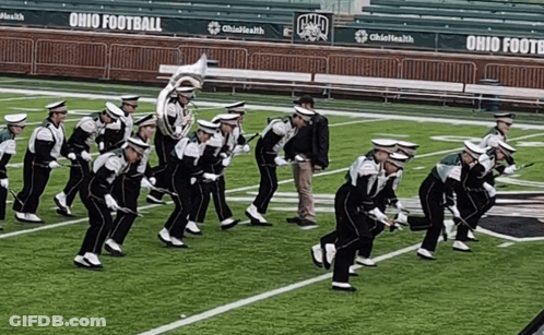A Marching Band Is Performing On A Field With Ohio Football Written On The Bleachers GIF