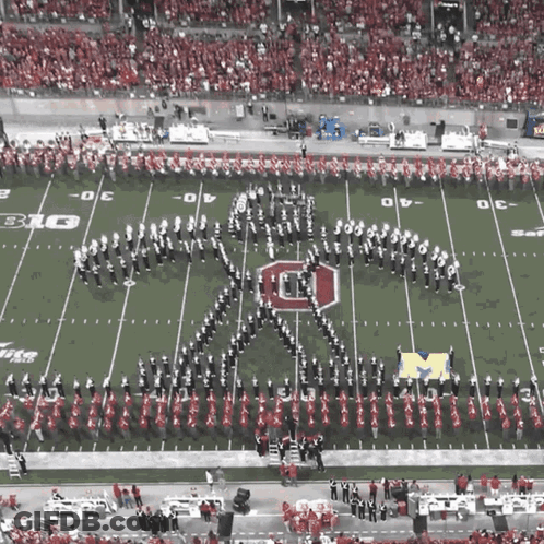 A Marching Band Performs On A Football Field With The Letter O On It GIF