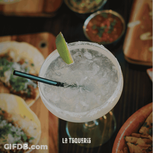A Margarita With A Straw And A Slice Of Lime Sits On A Table With La Taqueria Written On It GIF