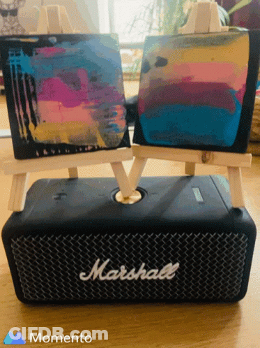 A Marshall Speaker Sits On A Table Next To Two Small Easels GIF