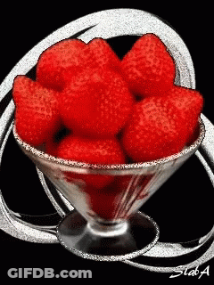 A Martini Glass Filled With Red Strawberries With A Black Background GIF