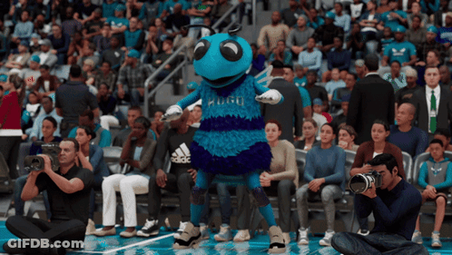 A Mascot For The Charlotte Hornets Stands In Front Of A Crowd Of People GIF