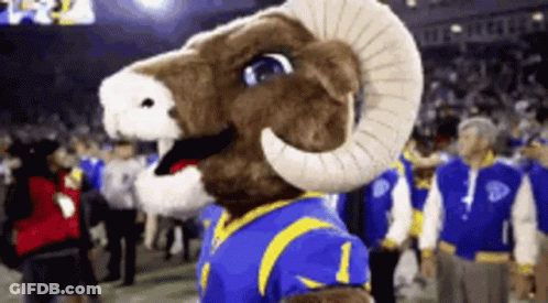 A Mascot For The Los Angeles Rams Is Standing On A Football Field GIF