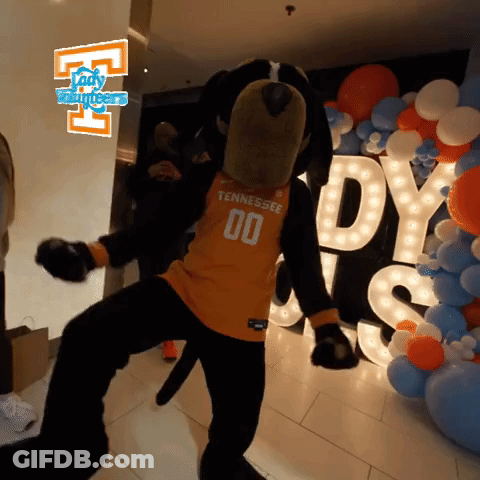 A Mascot From Tennessee Is Dancing In Front Of Balloons And A Sign That Says Lady Volunteers GIF