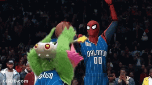 A Mascot Holding A Basketball Next To A Mascot Wearing An Orlando Jersey GIF