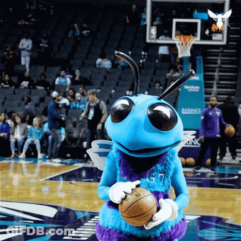 A Mascot Holding A Basketball On A Basketball Court GIF