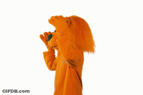 A Mascot In An Orange Ing Lion Costume Waves GIF