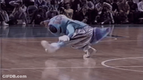 A Mascot Is Doing A Trick On A Basketball Court While A Crowd Watches . GIF
