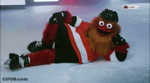 A Mascot Is Laying On The Ice Wearing A Hat And Gloves GIF