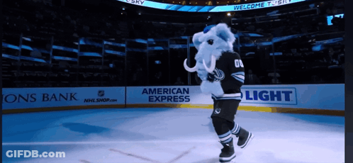 A Mascot Is On The Ice In Front Of An American Express Banner GIF