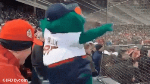 A Mascot Is Pointing At A Crowd Of People In A Stadium While Wearing A Jersey That Says Jelly . GIF