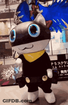 A Mascot Is Standing In Front Of A Building That Says Shibuya GIF