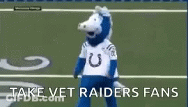 A Mascot Is Standing On A Football Field With The Words `` Take Vet Raiders Fans '' . GIF