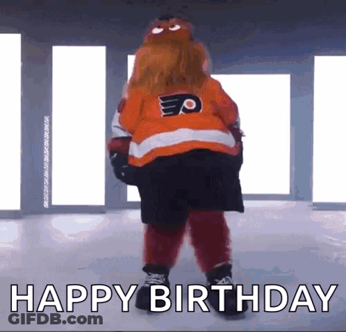 A Mascot Is Standing On A Ice Rink With The Words Happy Birthday Written Below Him . GIF