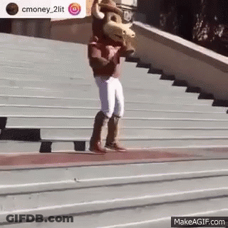 A Mascot Is Standing On A Set Of Stairs Holding A Bull . GIF