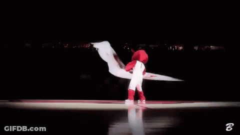 A Mascot Is Waving A Red And White Flag In A Basketball Court . GIF