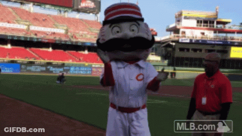 A Mascot On A Baseball Field With A Mlb.com Logo In The Background GIF