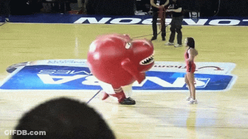 A Mascot On A Basketball Court With A Nba Logo On The Floor GIF