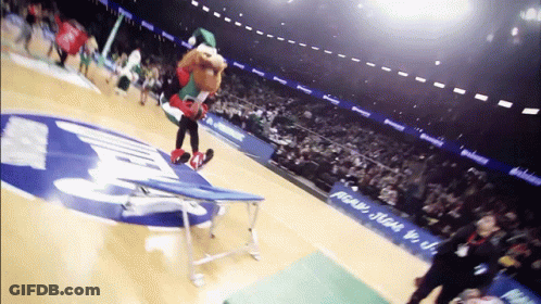 A Mascot Performs A Trick On A Trampoline In Front Of A Sign That Says ' Pecan ' On It GIF