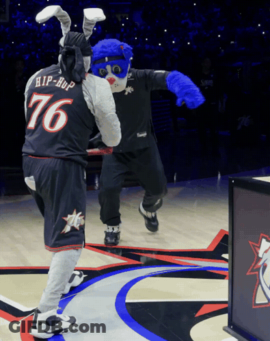 A Mascot Wearing A Number 76 Jersey Stands Next To Another Mascot GIF