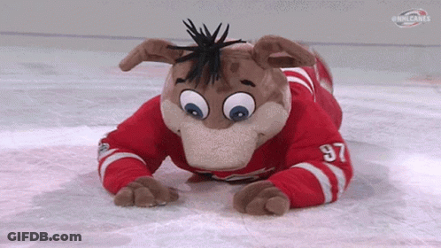 A Mascot Wearing A Red And White Jersey With The Number 97 On It Is Laying On The Ice . GIF